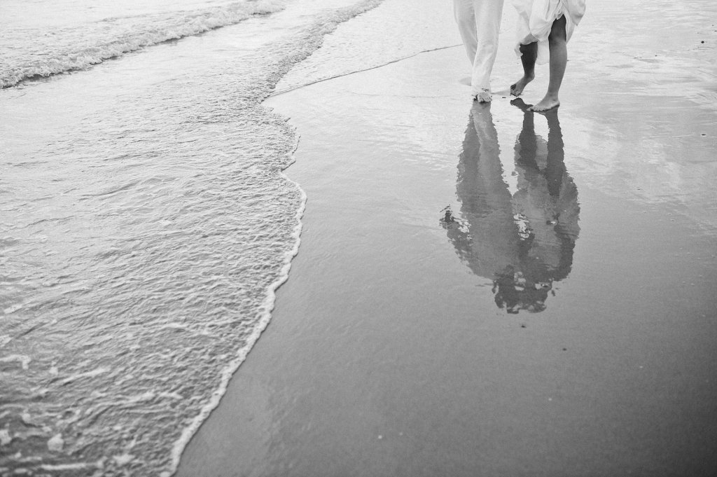 Photo reflection of bride and groom in the wet sand